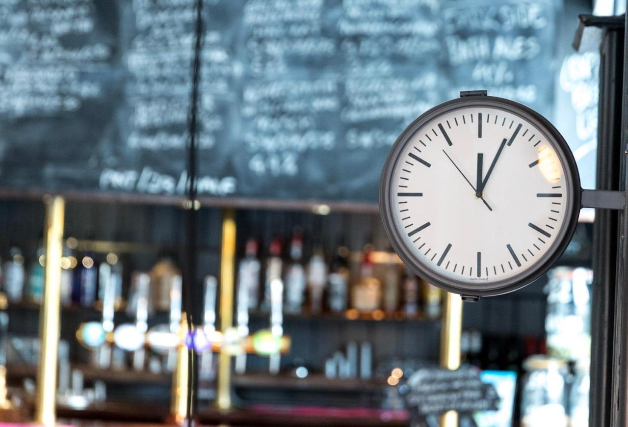 a clock on a pole in front of a bar at The Black Fox in Bath